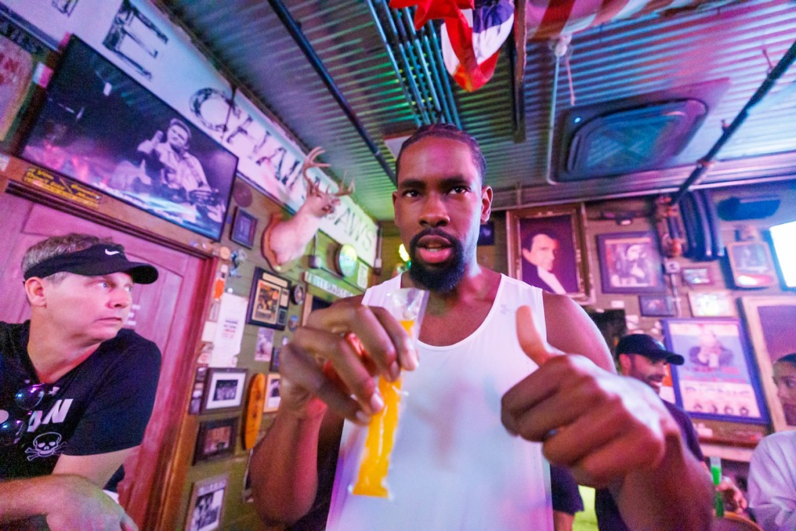 Runner toasting a post-run drink with a thumbs up inside the bar